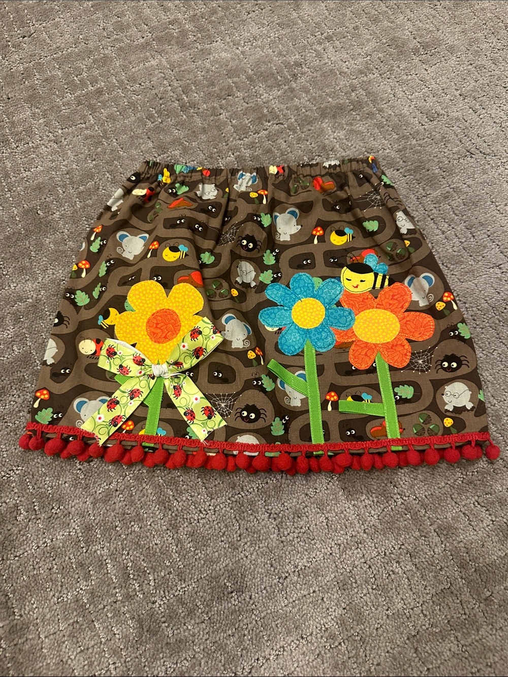 Freckled Chicken Girls Brown Flower Appliqué Skirt with Red Pom Trim